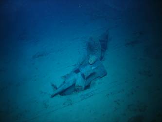 Stbd anchor embedded in steel plate from ship's side in debris field